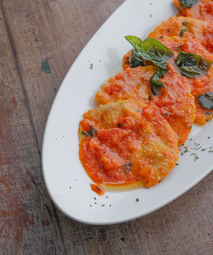 A plate worth slowing down for. Ravioli al Pomodoro — rich tomato sauce, delicate ravioli, and fresh basil bringing it all together.